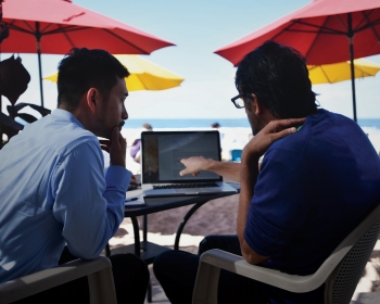 杨博士和德赛博士在海滩上研究人工智能学习模式的照片